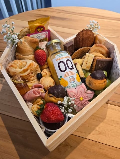 Cesta da Platteria em caixa de coração com frutas, pães, doces e flores.